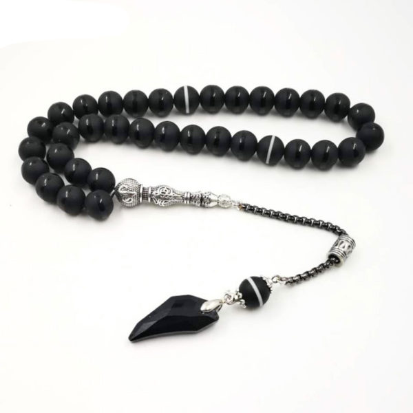 Chapelet musulman noir de 33 perles en agate et avec un pompon en cristal sur un fond blanc