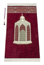 Un tapis rouge décoré d'un monument arabe est étendu sur un fond blanc. Il est orné de détails dorés et de franges blanches. Un chapelet de prière est posé sur la gauche.