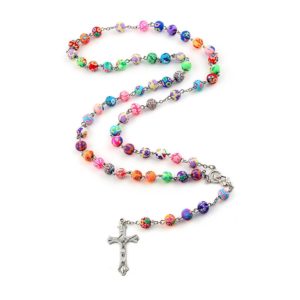 Un chapelet catholique avec des perles multicolore à fleurs. Un long collier avec une estampe de la vierge marie et une croix de jésus au bout