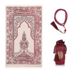 Un tapis de prière rose foncé est étendu sur un fond blanc. Un chapelet assorti est à sa droite et une petite sacoche également.