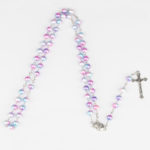 Chapelet catholique avec des perles en acrylique nacrées en nuances de rose bleu et violet. Les perles sont montée sur une chaine argentée avec une estampe de la vierge et une croix portant jesus