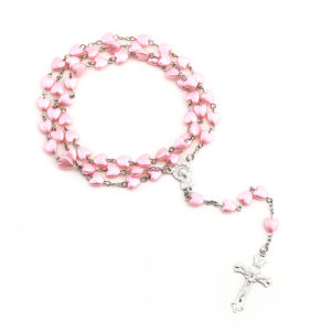 Chapelet catholique avec des perles en forme de coeur rose sur une chaine en argent. Un médaillon de marie sous une alveole et une croix de jesus