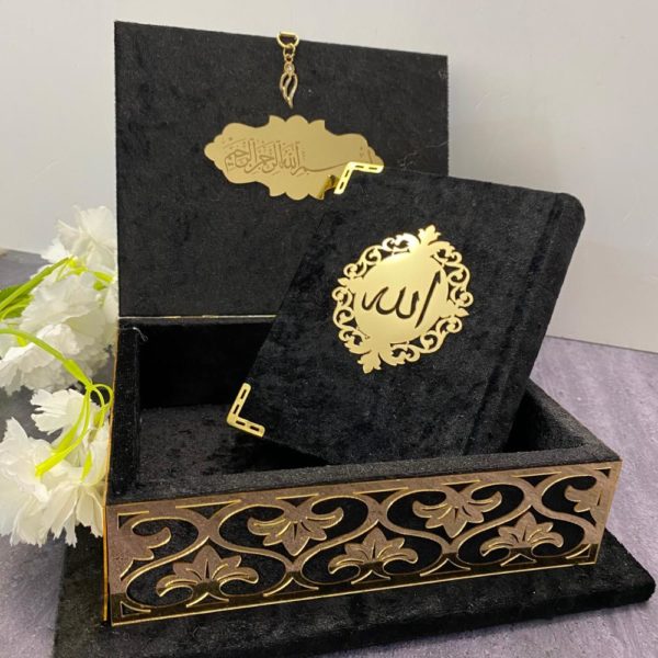Somptueux coffret en velours noir avec détails dorés renfermant un Coran en arabe de couleur assortie.