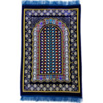 Tapis de prière en velours bleu avec des motifs à fleurs et un motif de vitrail au centre.