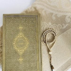 Superbe ensemble d'accessoires de prière dorés : un Coran à la couverture rigide et très élégante, un chapelet doré et un tapis beige et doré très féminin.