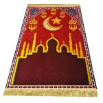 Tapis de prière rouge en velours épais. Le tapis a un motif de grande mosquée avec un croissant de lune et une étoile au dessus, en doré.