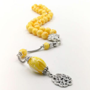 Sublime chapelet jaune formé de 99 perles en résine. Finitions en métal argenté, gland en rosace
