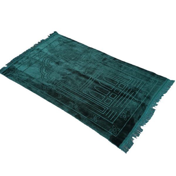Un tapis rectangulaire à franges vert sapin est placé sur un fond blanc unis. Il est en velours.