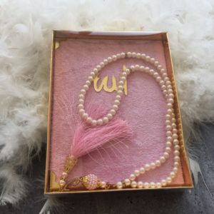 ensemble de prière comprenant un Coran de poche à la couverture en velours rose très féminin et un chapelet assorti de 99 perles, le tout soigneusement emballé dans un coffret.