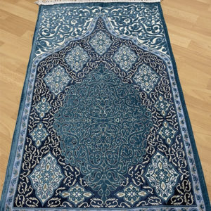 Tapis de prière musulman bleu. Motifs de style persan en nuances de bleu qui forment une porte orientale.