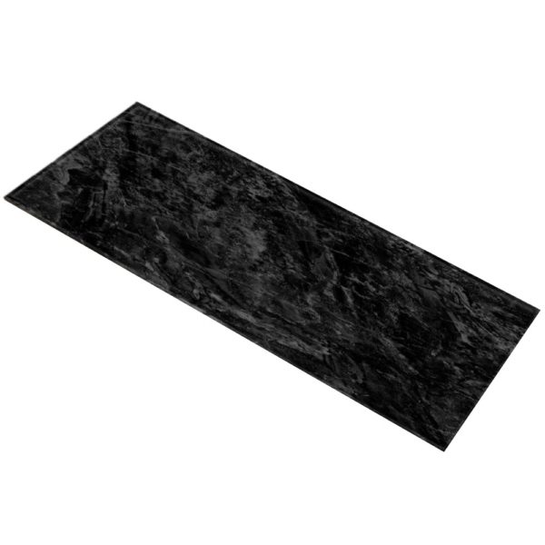 Un tapis de prière rectangulaire à motif marbre noir obsidienne est étendu sur un fond blanc vide.