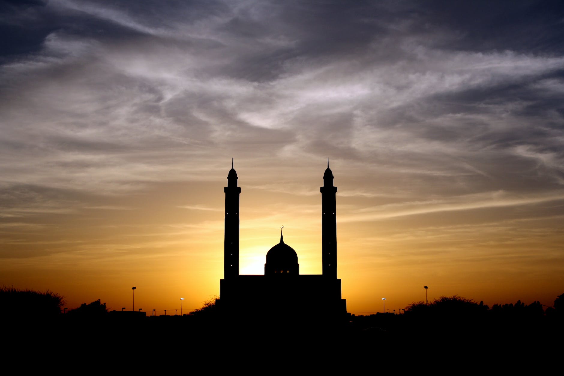 silhouette of mosque below cloudy sky during daytime